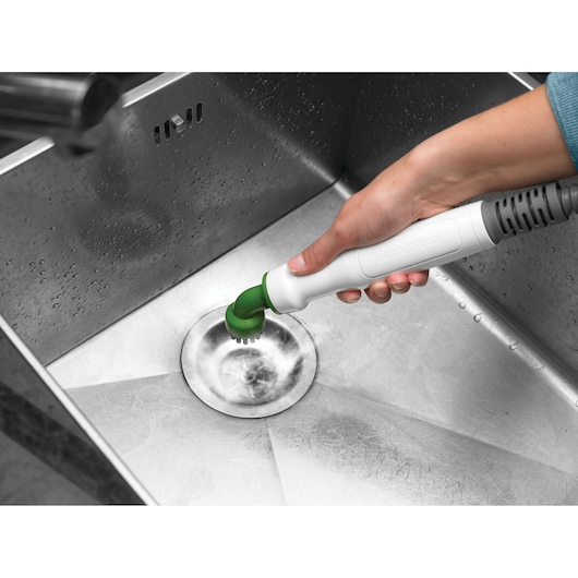 Photo of BLACKDECKER FSMH1351SM steam cleaner with green brush cleaning a stainless steel sink.