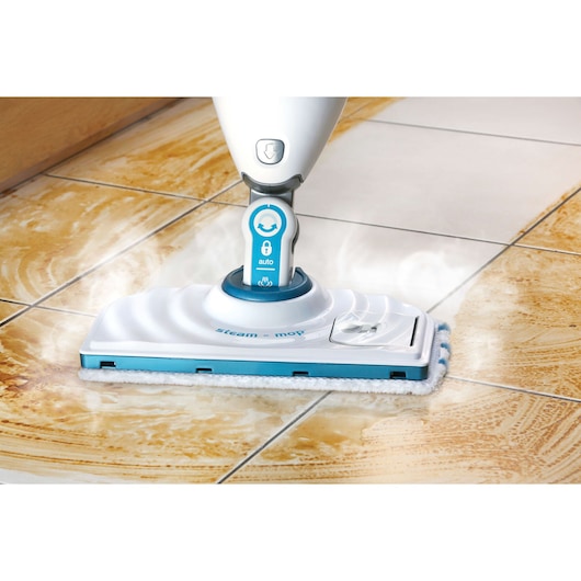 BLACK+DECKER FSMP20 steam mop cleaning dirty tile floor, close-up showing steam and cleaning action.
