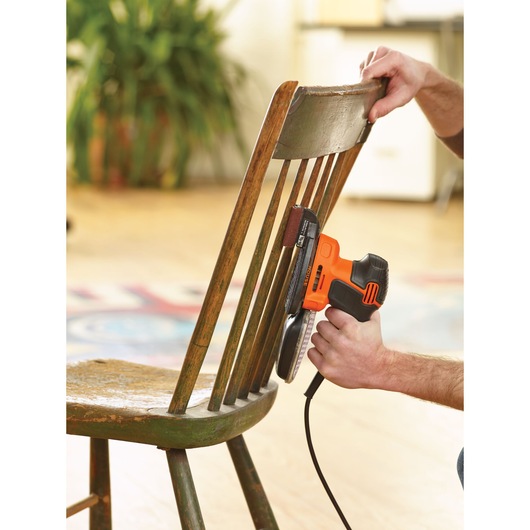 BLACKDECKER KA2000 electric sander used to sand wooden chair spindles indoors.