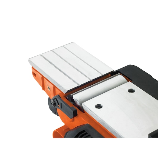 Close-up of a BLACK+DECKER power planer tool showing its metal planing surface and adjustment knob.