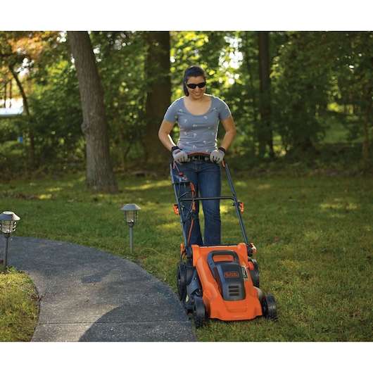 BLACKDECKER LM2000 electric lawn mower in use on grass, front outdoor view.