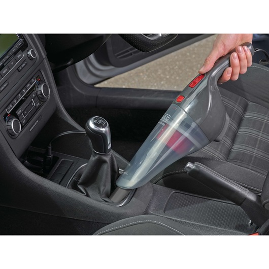 BLACKDECKER NV1210AV handheld vacuum cleaning car interior, shown in use on gear shift area.