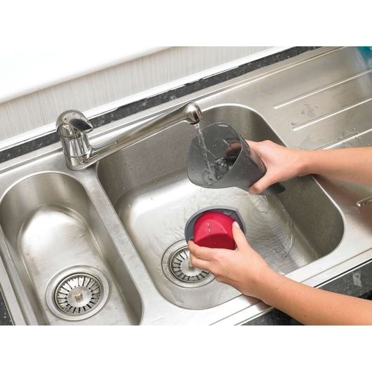BLACKDECKER NV3610N vacuum dust container and filter being washed in a sink, close-up top view.