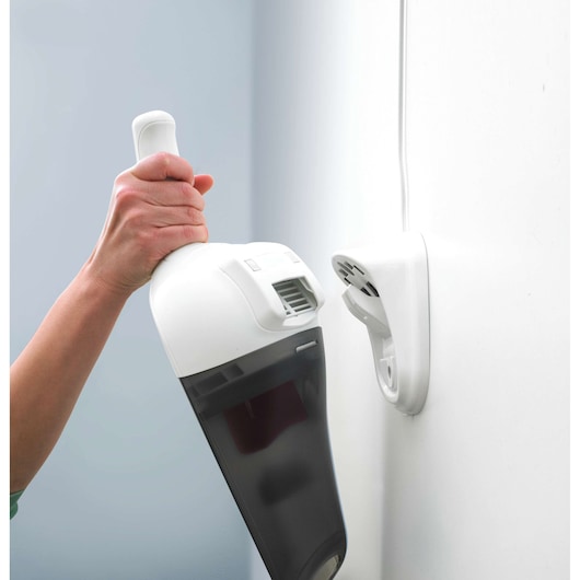BLACKDECKER NV3620N handheld vacuum cleaner being mounted on white wall charger.