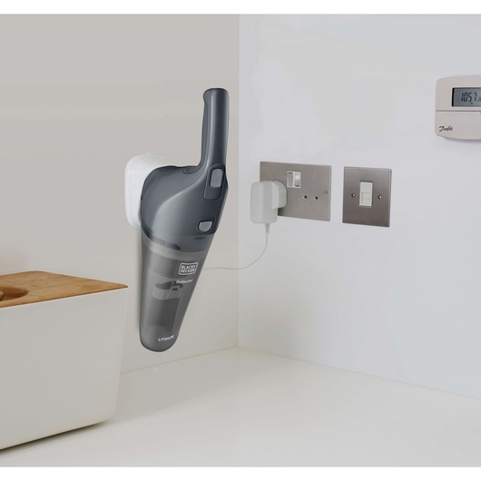 BLACKDECKER NVB215WA handheld vacuum on wall mount charging in a modern kitchen setting.