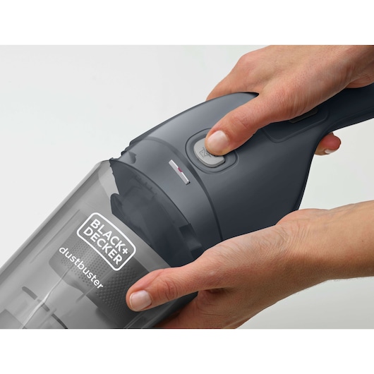 Close-up photo of BLACK+DECKER NVB215WA handheld vacuum cleaner in use, grey color, dustbuster label visible.