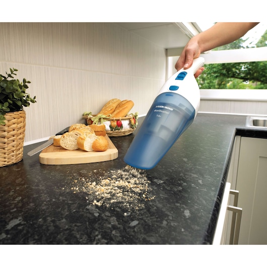 BLACKDECKER NW3620N handheld vacuum cleaning bread crumbs on kitchen counter near bread basket.