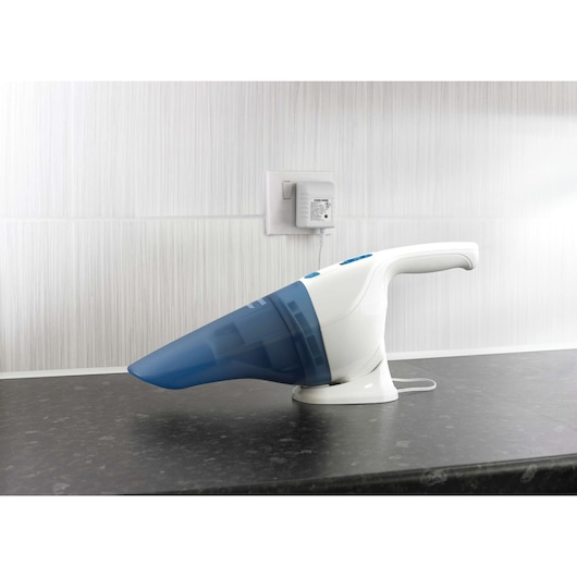 BLACKDECKER NW3620N handheld vacuum cleaner with blue dust container on charging base, side view on countertop.