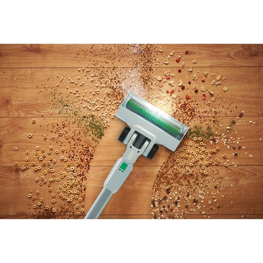 BLACKDECKER REVSV18D1 cordless vacuum photographing cleaning cereal and debris from hardwood floor, top view.