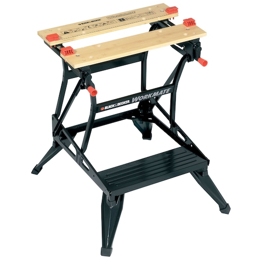 A BLACK+DECKER Workmate portable workbench with a folding black metal frame, wooden worktop with integrated ruler markings, and red clamps. Designed for holding materials securely during DIY or woodworking tasks.