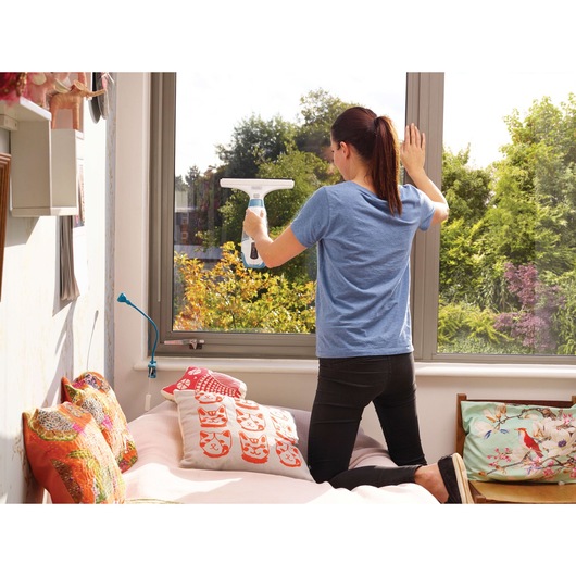 Photo of BLACKDECKER WW100 window vacuum being used to clean a large window in a bedroom.