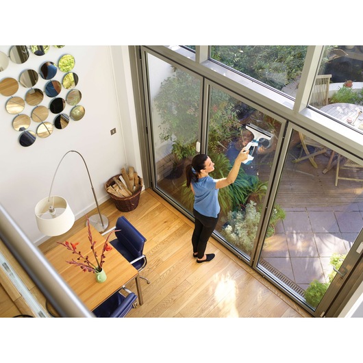 BLACKDECKER WW100 window cleaning tool used on glass door in modern living room with wooden floor.