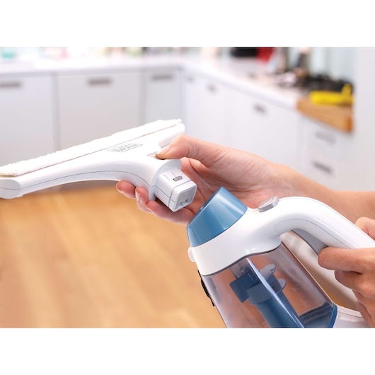 BLACKDECKER WW100 handheld window cleaner in white and blue, close-up of attachment in a kitchen setting.